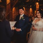 Bride and groom exchanging wedding vows indoors.