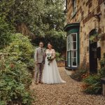 Bride and groom outside rustic stone house