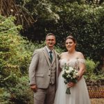 Bride and groom in garden on wedding day.