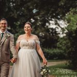 Smiling couple walking on wedding day outdoors.