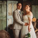 Bride and groom posing in rustic setting.