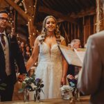 Couple exchanging vows in rustic wedding ceremony.