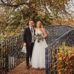 Bride and groom on bridge in autumn setting