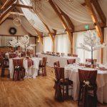 Elegant wedding reception hall with decorated tables.