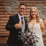 Bride and groom celebrating with champagne and flowers.