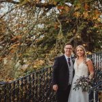 Bride and groom on a bridge in autumn.