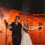 Bride and groom spraying champagne joyfully