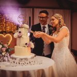 Bride and groom cutting wedding cake