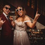 Bride and groom wearing heart-shaped sunglasses celebrating.