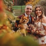 Happy couple with dog at autumn wedding