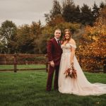 Bride and groom in autumn countryside setting.