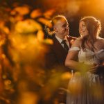 Bride and groom embracing in warm lighting.