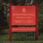 Holmewood Hall wedding venue sign in garden setting.