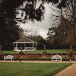 White gazebo in a picturesque garden setting