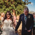 Bride and groom smiling, confetti in the air.