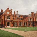 Historic red-brick mansion with manicured lawn.