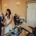 Bride and groom exchanging vows at indoor wedding ceremony.