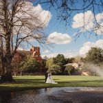 Bride and groom in manor garden with fountain.