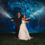 Couple celebrates outdoors with champagne at night.