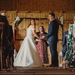 Bride and groom holding hands in wedding ceremony.