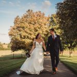 Couple walking in garden on wedding day