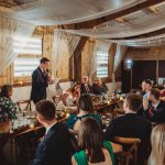 Wedding reception speech in rustic barn setting.