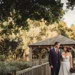 Bride and groom on wooden bridge, outdoor wedding.