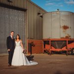 Couple in wedding attire, industrial background.