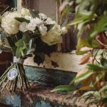 White rose bouquet on rustic windowsill.