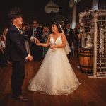 Bride and groom dance at rustic wedding reception