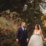 Bride and groom walk in garden