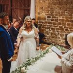 Bride and groom holding hands during wedding ceremony.