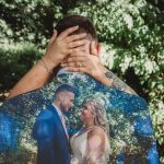 Wedding couple embraced against forest backdrop.