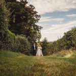 Bride and groom walking in garden pathway