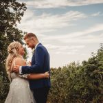 Bride and groom smiling outdoors in nature.