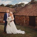 Bride and groom outside rustic building