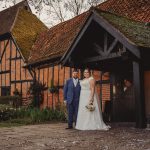 Bride and groom outside rustic brick barn.