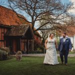 Bride and groom walking at rustic wedding venue.