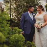 Bride and groom smiling in garden