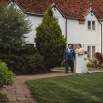 Couple walking near historic building on wedding day.