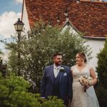 Bride and groom smiling outdoors at wedding.