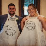 Bride and groom holding personalised aprons.