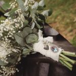 Wedding bouquet with memorial charms on tractor step.