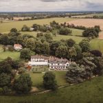 Aerial view of countryside manor and fields.