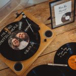 Personalised vinyl record guestbook on a wooden table.