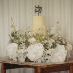 Wedding cake with flowers on wooden table