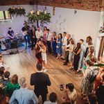 Wedding reception with couple's first dance, surrounded by guests.