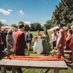 Outdoor wedding ceremony with guests and bride walking.