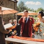 Outdoor wedding ceremony with bride and groom smiling.