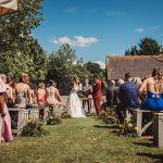 Outdoor wedding ceremony with guests seated.